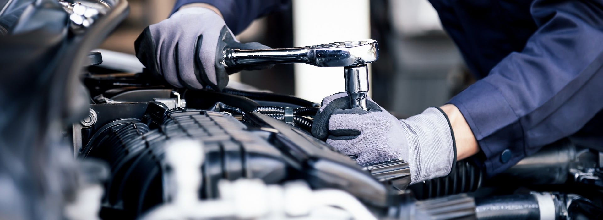 Professional mechanic working on the engine of the car in the garage. Car repair service. The concept of checking the readiness of the car before leaving.